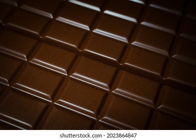 Tiles Of Black Chocolate As Background, Close-up With Selective Focus. Contains Chrominance Noise And Special Film Grain. 