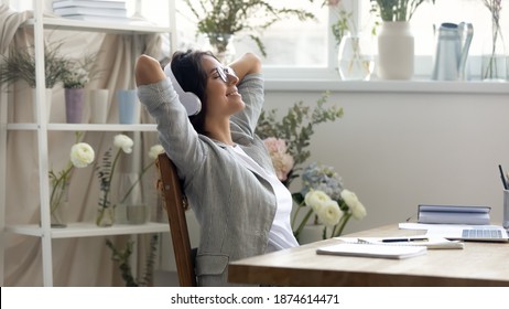 Till There Are No Customers. Happy Young Woman Florist Decorator Spending Free Minute At Office Table. Peaceful Lady Flower Shop Worker Resting In Wireless Earphones Enjoying Calm Music From Playlist