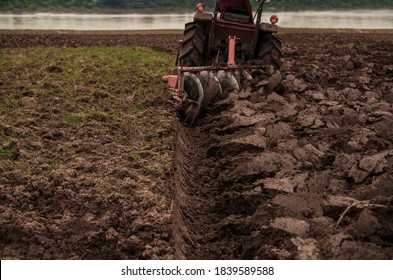 Tilling And Prepare Soil For Planting By Machine Tools For Plowing Field Or A Tractor. Agricultural Industry That Requires The Use Of Machinery To Help Reduce The Amount Of Work And Workload.