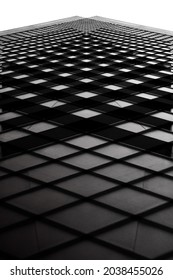Tilt black and white photo of glass facade. Close-up of abstract modern architecture fragment. Minimalist building exterior background. Geometric pattern with angular structure.