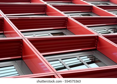 Tilt Low Angle Photo Of Residential Or Office Building Fragment With Windows In Red Frames. Abstract Modern Architecture Detail In Metallic Colors.