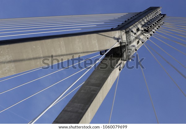 Tilt photo of cable-stayed bridge /\
suspension bridge against the background of blue sky. Modern urban\
architecture. Hi-tech cityscape\
fragment.
