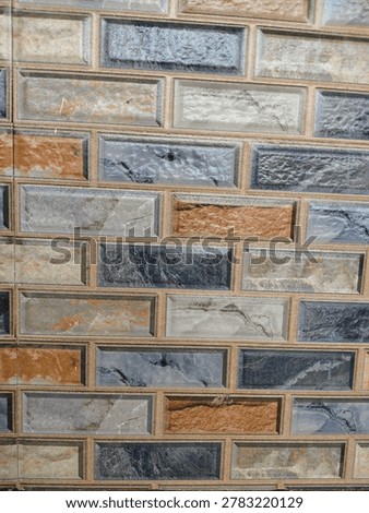 Tilte :Modern 3D textured ceramic wall tiles with multicolored brick pattern and beveled edges.

Description
A high-resolution close-up of decorative wall cladding featuring a rectangular brick-style design. The tiles showcase a mix of earthy tones, including terracotta orange, slate grey, and stone beige, with realistic marble and granite textures. The beveled edges create a 3D embossed effect, making it ideal for interior design, home renovation, or architectural backgrounds