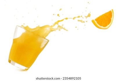 Tilted drinking glass with orange juice spilling out and a flying orange slice isolated on white background. Real studio photo.
