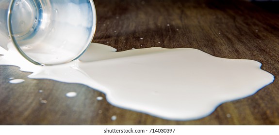 A Tilted Glass With Milk Is Lying On A Table