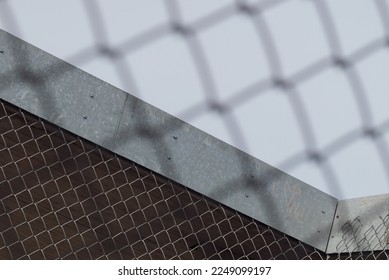 Tilted view of a fenced in structure seen through a chain link fence