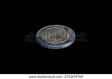 Tilted view obverse side of a 2004 Austrian 2 euro coin featuring peace activist Bertha von Suttner. The bimetallic surface displays her portrait, the year, and twelve stars on the outer ring.