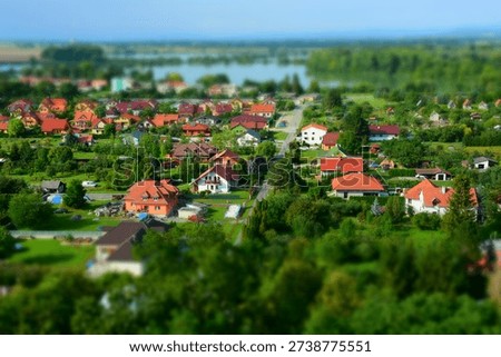 Tilt-shift miniature effect on a small town with red roofs and green gardens