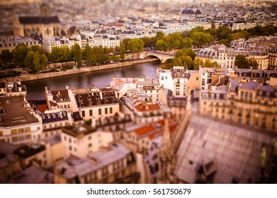 Tilt-shift miniature view across rooftops in Paris toward River Seine