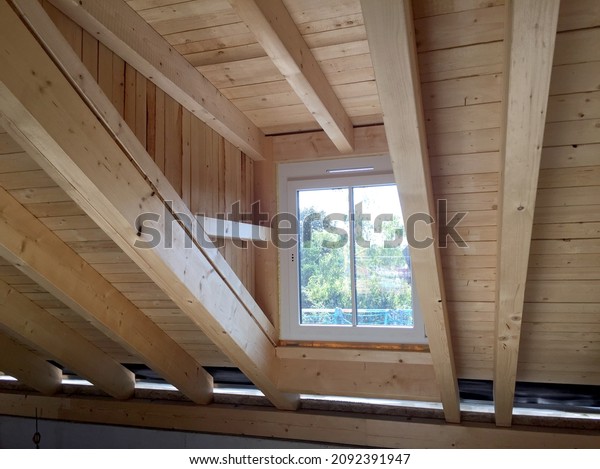Timber frame\
construction of a roof truss with dormer window in the attic floor\
of a new residential building, construction work before the\
interior construction of an\
apartment
