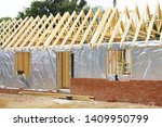 Timber frame house extension or annexe under construction with modern foil insulation and exterior brick wall