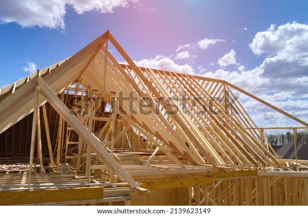 Timber frame\
house of gables roof on stick built home under construction new\
build roof with wooden beam\
framework