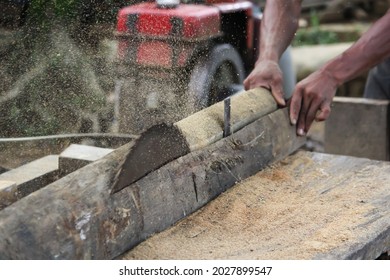 A Timber Mill Worker Cutting Tree With Saw Machine To Make Wood In Sajek, Bangladesh