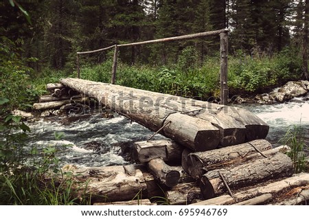 the timbered bridge passes through the forest river