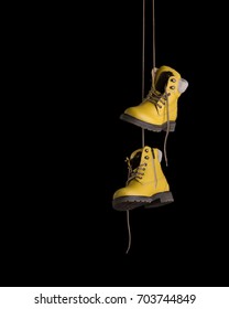 Timberland boots of yellow color hang on laces. - Shutterstock ID 703744849