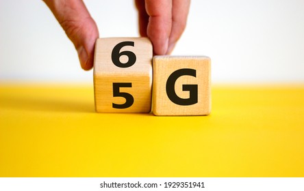 Time to 6G symbol. Businessman turns a wooden cube and changes sign 5G to 6G. Technology, business, network, communication and 6G concept. Beautiful yellow table. White background, copy space. - Shutterstock ID 1929351941