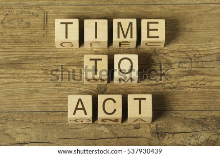 time to act ext on wooden cubes on a wooden background