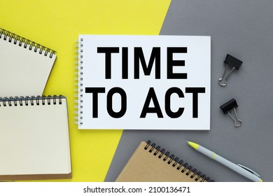 Time for Act . Opened notebook and other office equipment such as computer keyboard, pencil, stickers and glasses on wooden office desk. Yellow and grey color