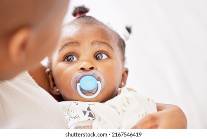 Is it time for an afternoon nap already. Shot of an adorable baby girl sucking a dummy while being held by her mother at home. - Shutterstock ID 2167546419