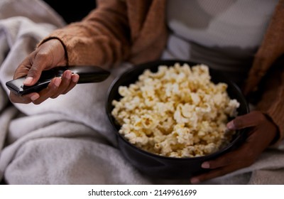 Time To Binge Watch Your Favourite Show. High Angle Shot Of An Unrecognizable Woman Eating Popcorn While Watching Tv At Home.