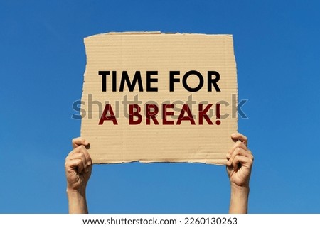 Time for a break message on a cardboard held by 2 hands with blue sky background. This text can be used for business concept about informing employee to ta a break.