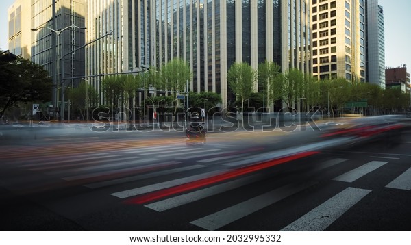 time of a busy crossroad in a big city in the\
evening. Cars stop at the traffic light and then move forward\
creating beautiful light trails. Crowds of pedestrians cross the\
road in their turn.
