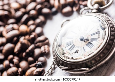 Time to coffe.Coffee beans with clock on the table