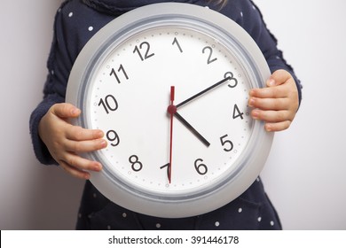 Time To Come Back Home. Child Holding Clock Which Shows After Five.