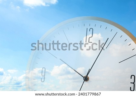 Time concept. Double exposure of blue sky with fluffy clouds and clock