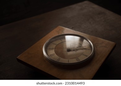 Time concept. Old rustic wall clock on old wooden table with copy space studio shot