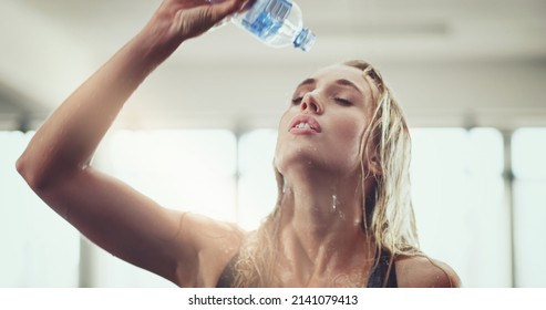 Time To Cool Off. Cropped Shot Of An Attractive Young Woman Pouring Water On Her Face During A Workout In The Gym.