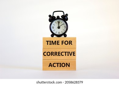 Time for corrective action symbol. Wooden blocks with words 'Time for corrective action' on a beautiful white background. Black alarm clock. Business, time for corrective action concept. Copy space.