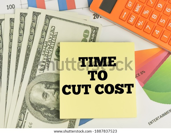 Time to cut cost\
written on yellow paper note with calculator,money and\
chart.Business and finance\
concept.