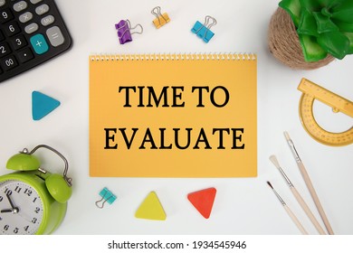 TIME TO EVALUATE is written in a notebook on an office table with office supplies.