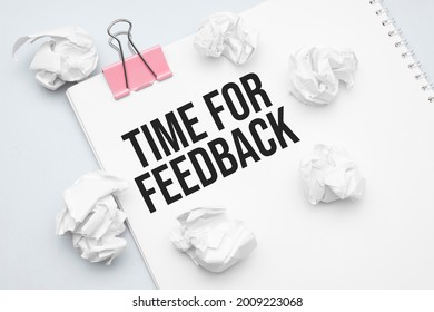 time for feedback. Blank sheet of paper, red paper clip, word Ideas and crumpled paper wads