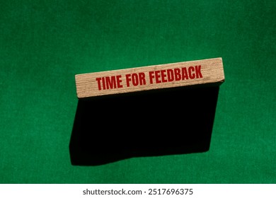 Time for feedback message written on wooden block with green background. Conceptual time for feedback symbol. Copy space.
