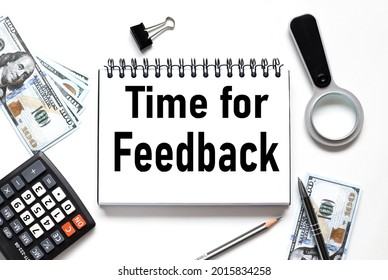 Time For Feedback, notebook on white workspace. near the notepad dollar bills and a calculator