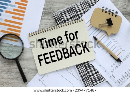 Time for feedback top view of a notebook with text. financial charts, pen