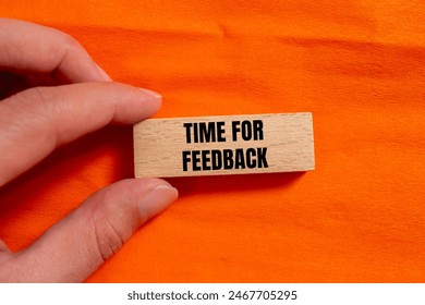 Time for feedback words written on wooden block with orange background. Conceptual time for feedback symbol. Copy space.