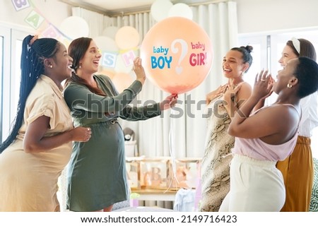 Time to find out. Shot of a group of women about to pop a balloon for a gender reveal during a baby shower.