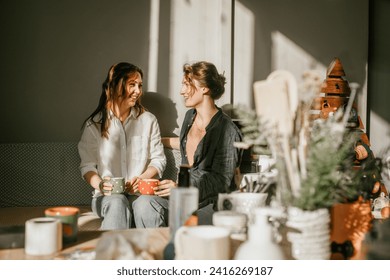 Time for intimate conversations: two women drinking tea in the sunshine in a cozy environment Girls friends talking over a cup of coffee - Powered by Shutterstock