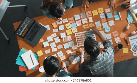 Time lapse of business team with casual outfit looking laptop screen and sharing idea. Aerial view of manager working and checking color palette at table with sticky notes and headphone. Symposium. - Powered by Shutterstock