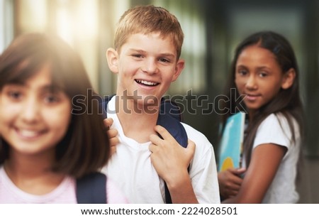 The time to learn is now. Portrait of elementary students standing in a school hallway.