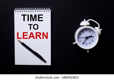 TIME TO LEARN is written in a white notepad near a white alarm clock on a black background.
