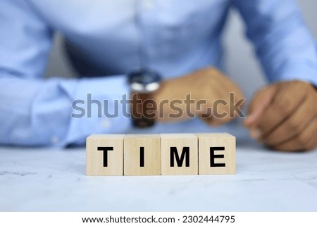 time letter on the wooden block conveys time control or completing projects on time, managing various business tasks to be effective on time.