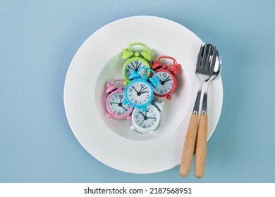 Time to lose weight , intermittent fasting eating control or time to diet concept , alarm clock with dish and spoon  decoration on a blue background - Shutterstock ID 2187568951