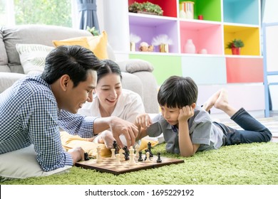 Time With Loved One Concept, Happy Asian Family Playing Chess Game In The Living Room Together.