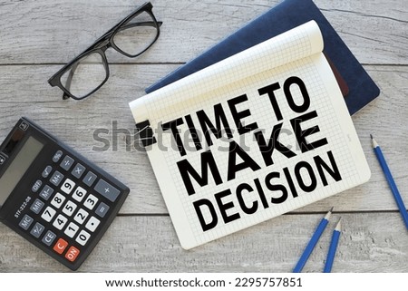 time to make decision notepad with clip on blue notepad near calculator. text on the page
