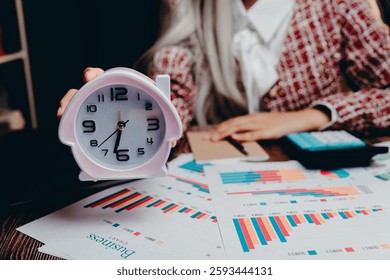 A Time Management Concept with Charts and Clock in Office Setting, Business concept