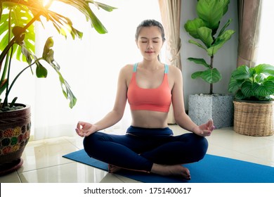 Time for meditation, yoga session, well-being concept. Girl wearing  sporty pants rolling fitness mat before, after class in yoga studio club or at home. Hands and legs close up